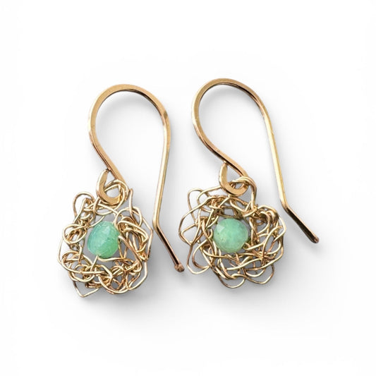 Pair of gold earrings with green gemstones on a white background