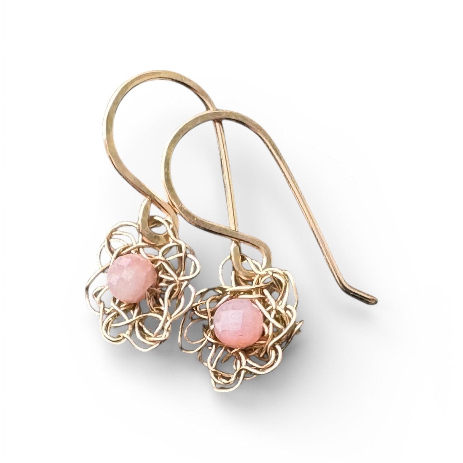 Gold earrings with pink stones on a white background