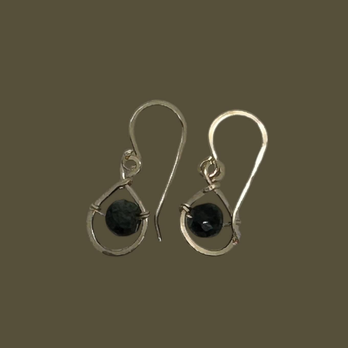 Studio photo of the Gold Filled Emerald Dew Drop Earrings on the bronze background