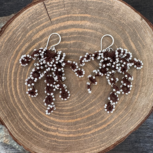 Pair of crochet beaded earrings on a wooden surface