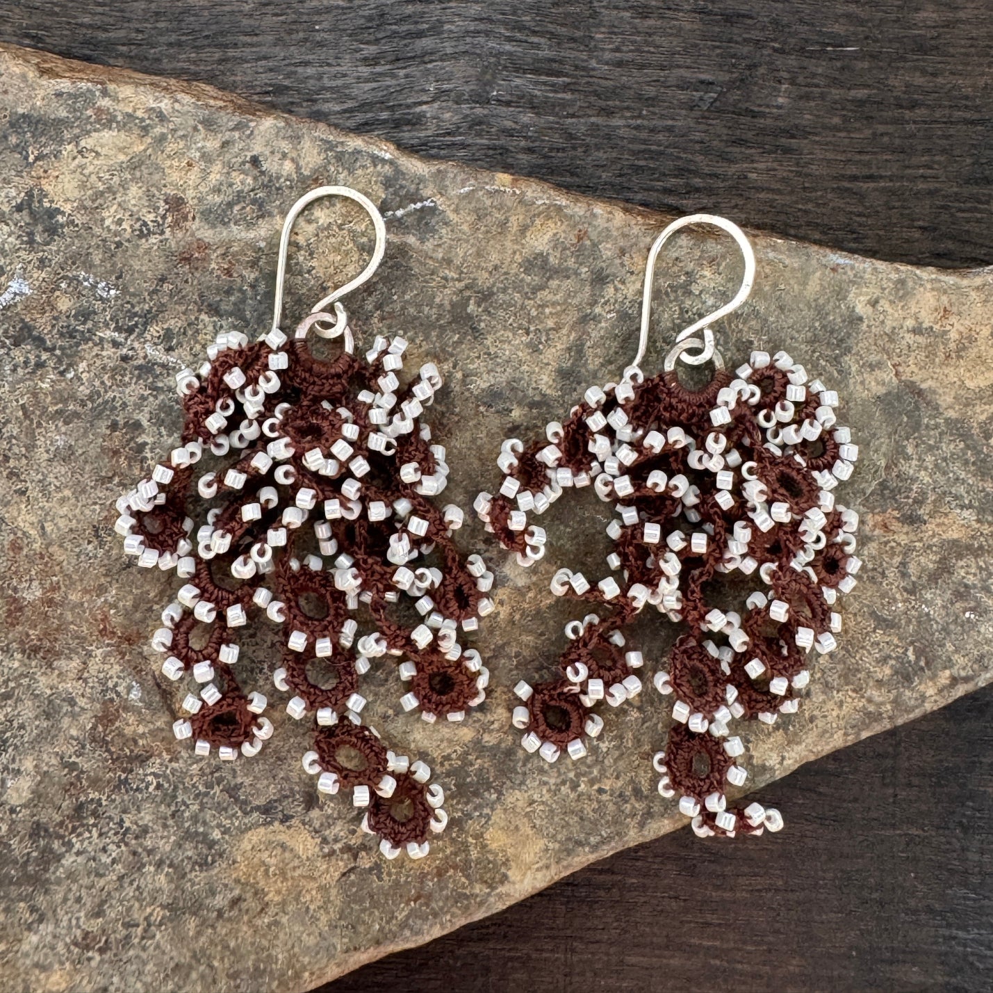 Beaded earrings on a stone surface