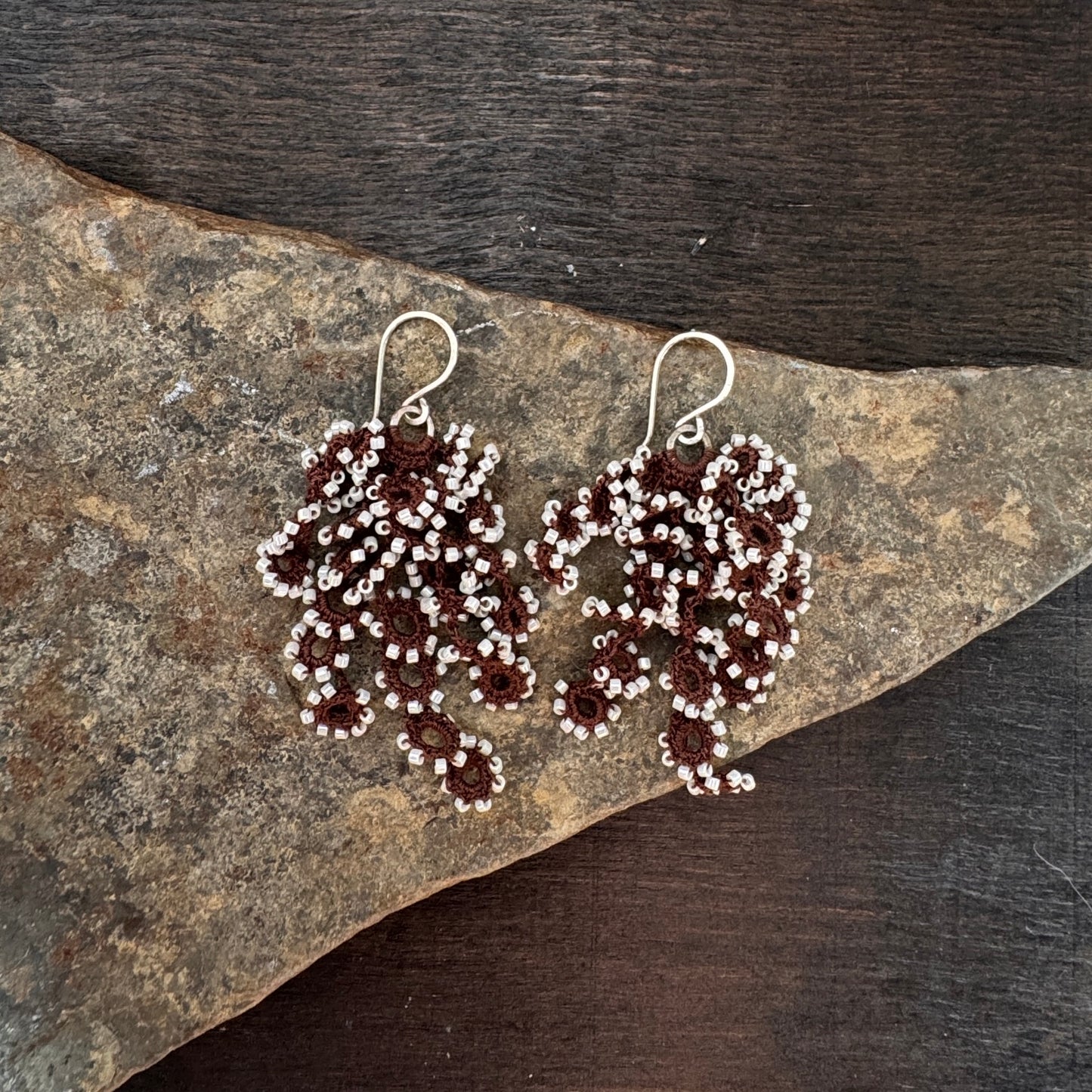 Pair of beaded earrings on a stone surface