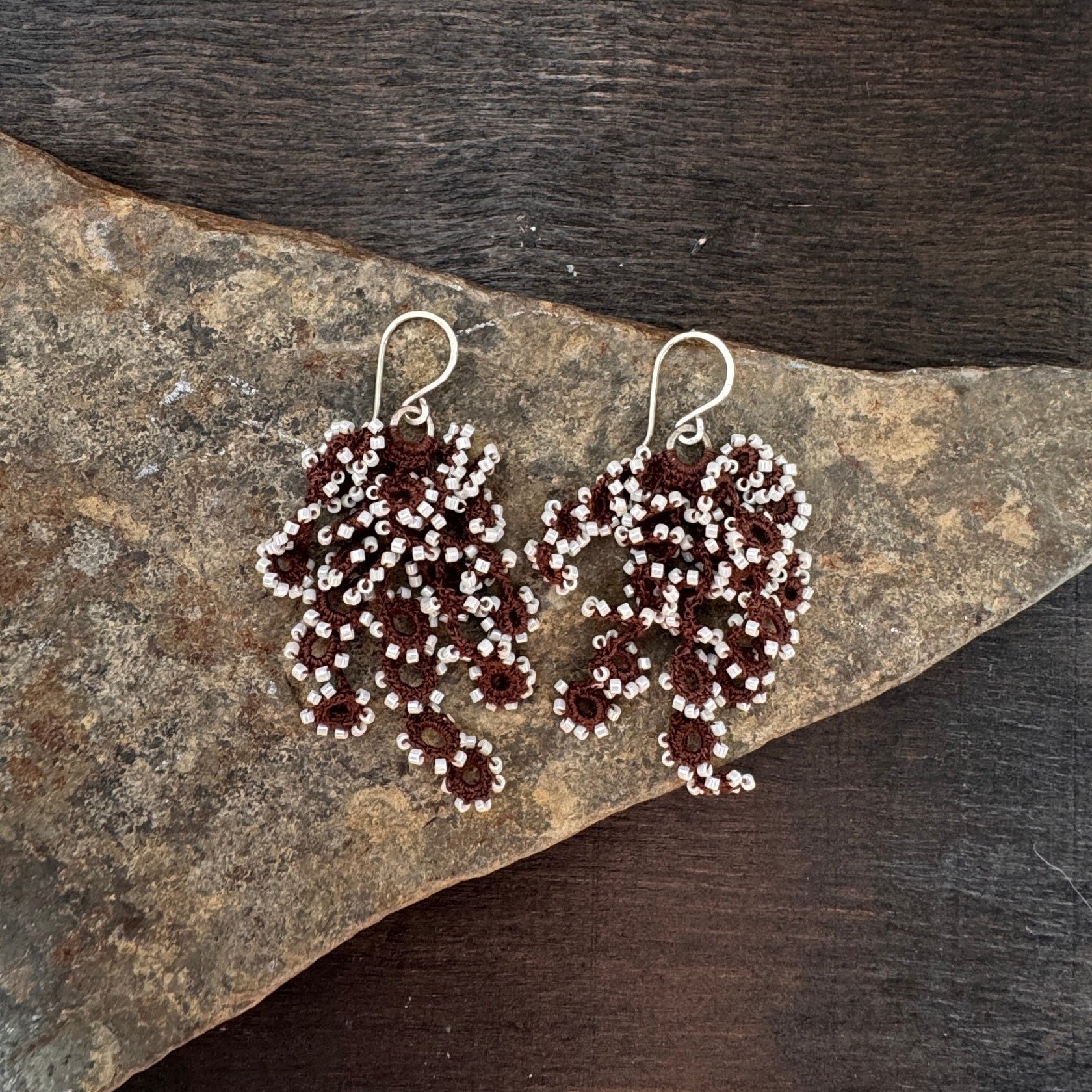 Pair of beaded earrings on a stone surface