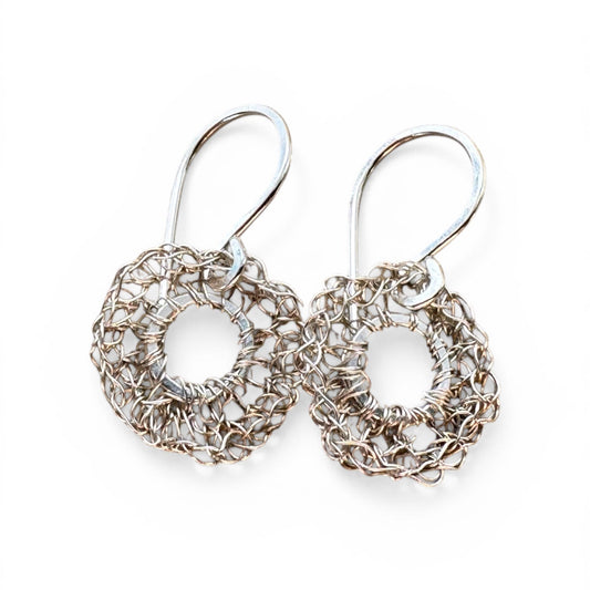 Pair of silver circular earrings on a white background
